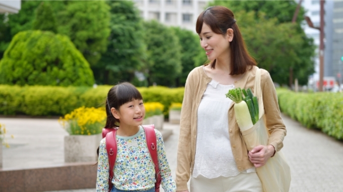 小学生の子供と一緒に帰る母親