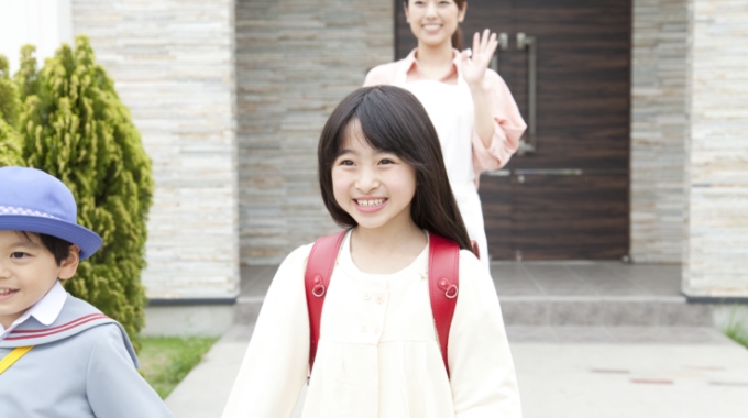 学校へ行く子供と見送る母親